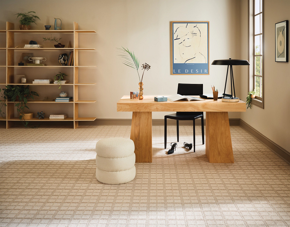 Beige grid-patterned carpet in a home office with a wooden desk.