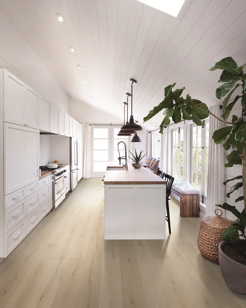 Light oak wood-look flooring in a bright white kitchen with a center island.