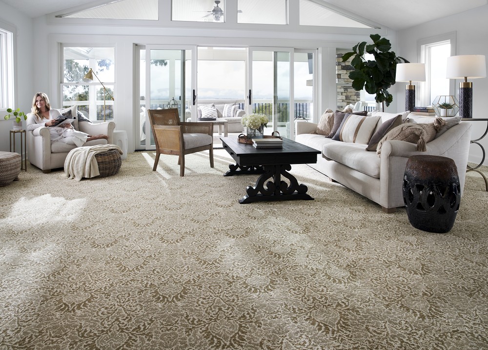 Sunlit living room featuring beige damask patterned carpet.
