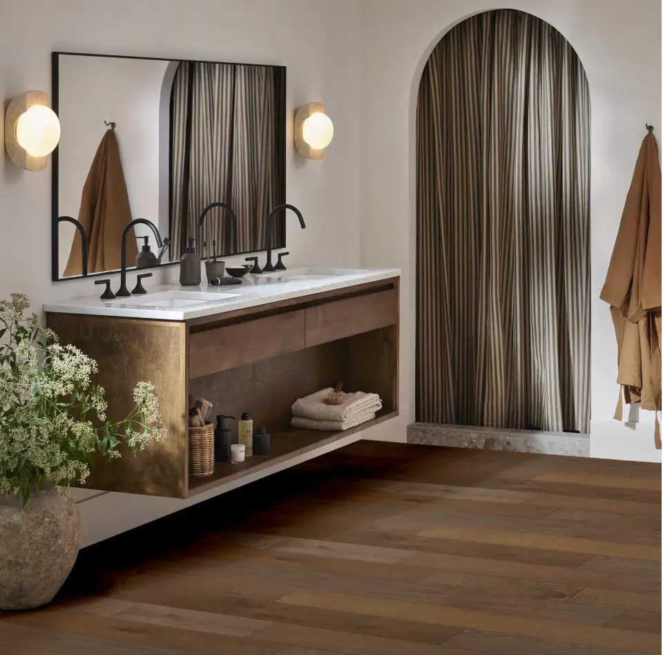 Dark brown wood flooring in an elegant bathroom featuring a floating double vanity.