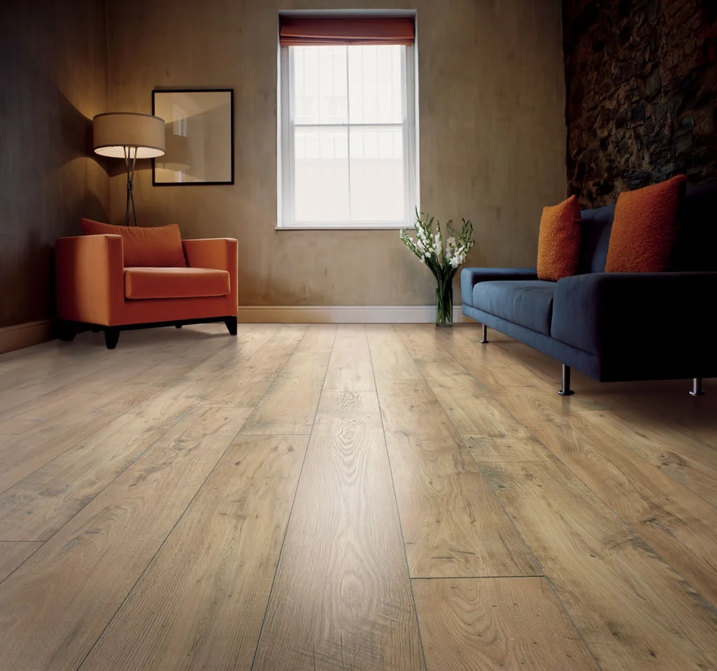 Light oak wood-look flooring in a living room with an orange armchair and blue sofa.